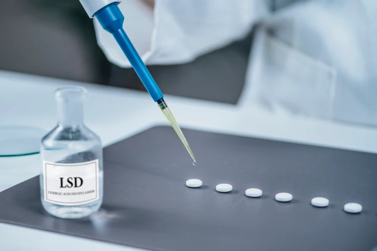 Scientist preparing small doses of LSD in laboratory.