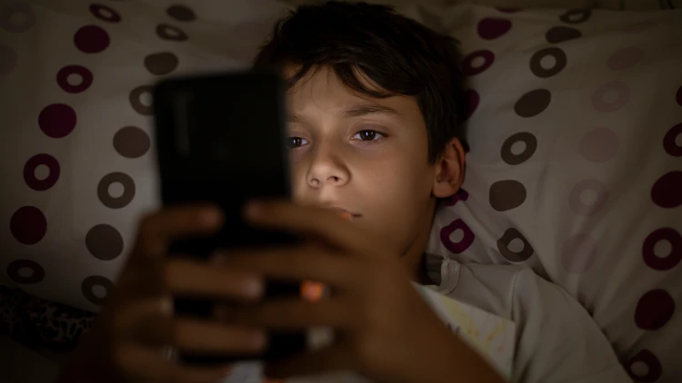 A boy browsing on his smartphone.