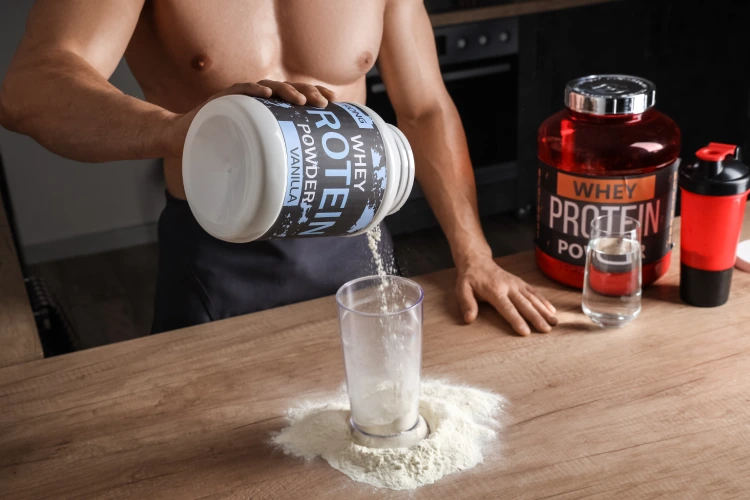 Man pouring protein powder into glass. Man pouring protein powder into glass.